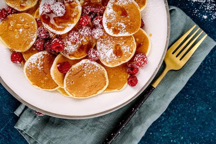 assiette de pancakes avec fruits rouges et sucre glace